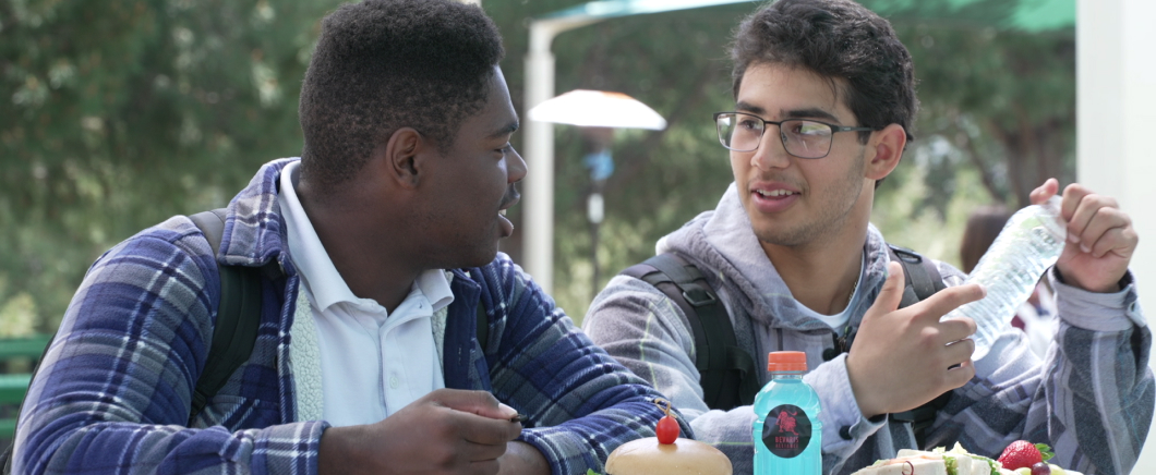 Image of two high school aged boys eating lunch together.