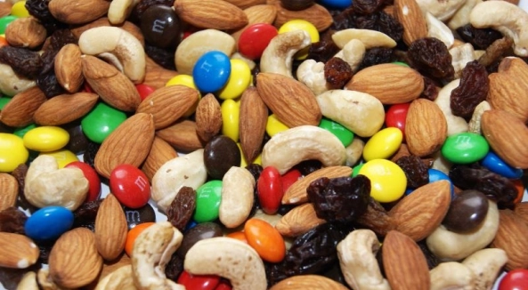 Image of a mix of peanuts, chocolate candies, raisins, cashews, and almonds.